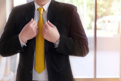 Midsection of man holding umbrella