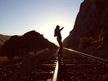 Man standing on railroad track against sky