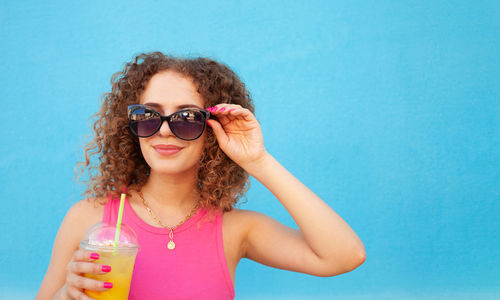 Beautiful happy woman with orange cold juice, concept summer drinks, rest and vacation. blue 