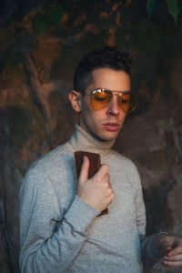 Portrait of young man wearing sunglasses standing outdoors
