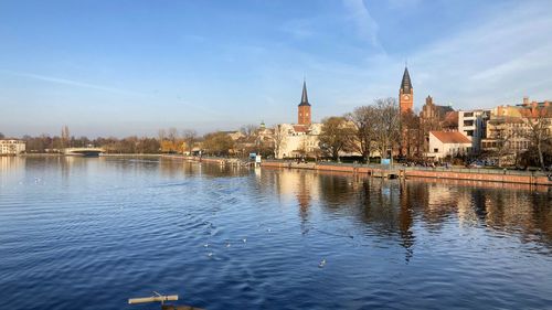 River amidst buildings in city against sky