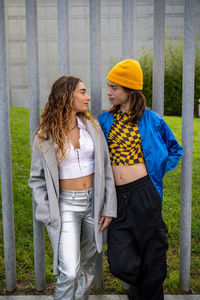 Portrait of smiling young woman standing against wall