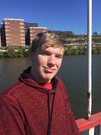 Portrait of young man against river