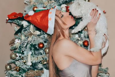 Portrait of young woman holding christmas tree