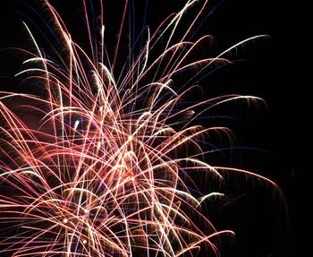 Low angle view of firework display at night