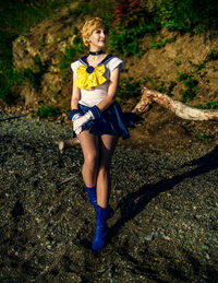 Full length of young woman sitting on rock