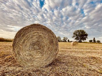 Hay bales on field against sky