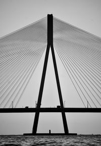 Low angle view of suspension bridge over sea against sky