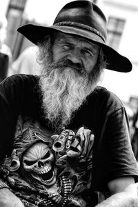 Portrait of man wearing hat sitting outdoors