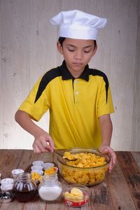 Boy preparing food on table at home