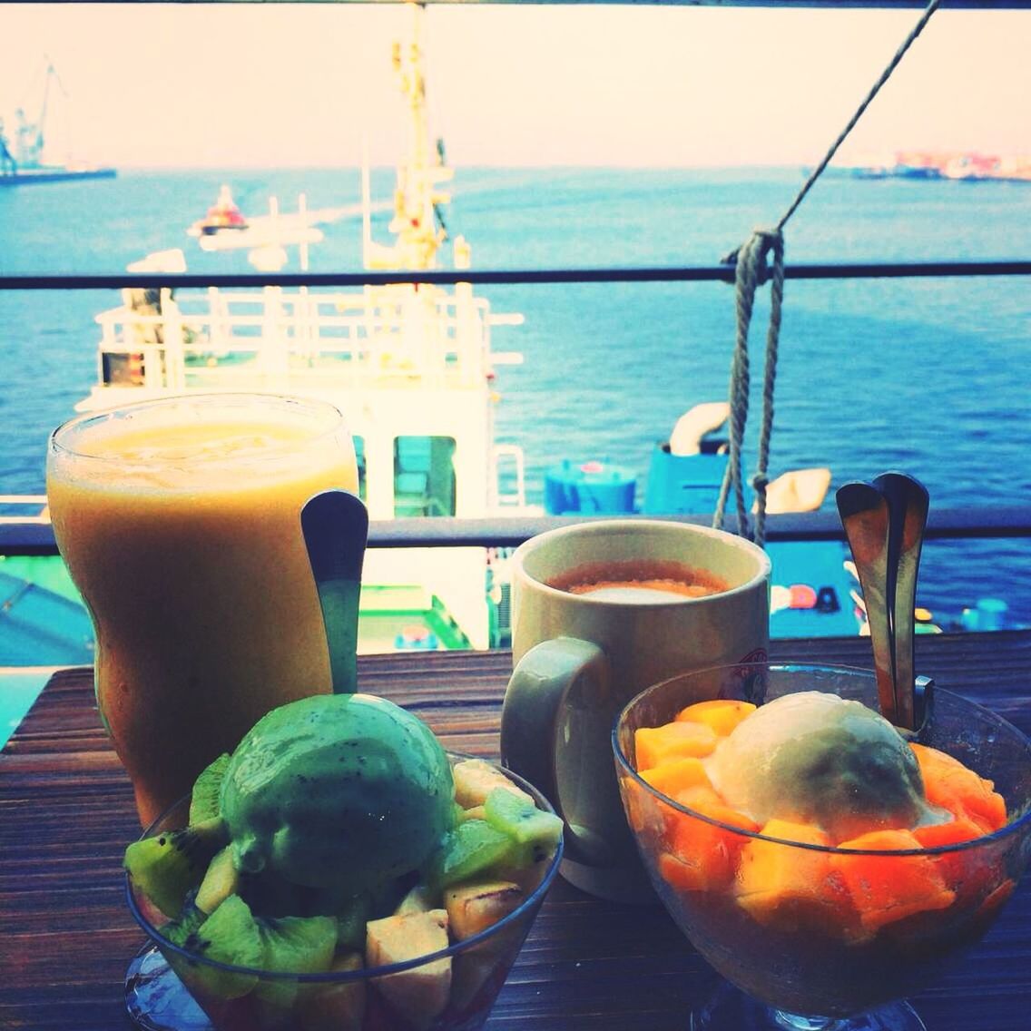 food and drink, drink, table, sea, freshness, refreshment, water, healthy eating, horizon over water, still life, food, blue, fruit, drinking glass, juice, close-up, sunlight, no people, focus on foreground, outdoors