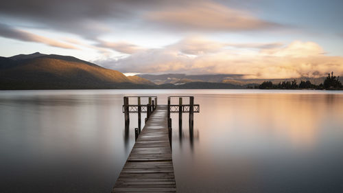 Pier over lake against sky