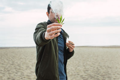 Full length of man standing on beach against sky