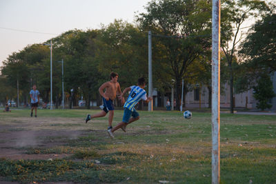 Group of people playing soccer on field