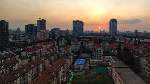 High angle view of buildings in city during sunset