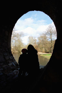 Silhouette people sitting against sky