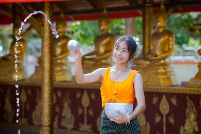 Portrait of young woman standing in city