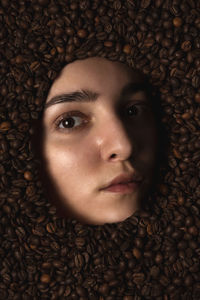 Close-up portrait of woman face  in coffee beans
