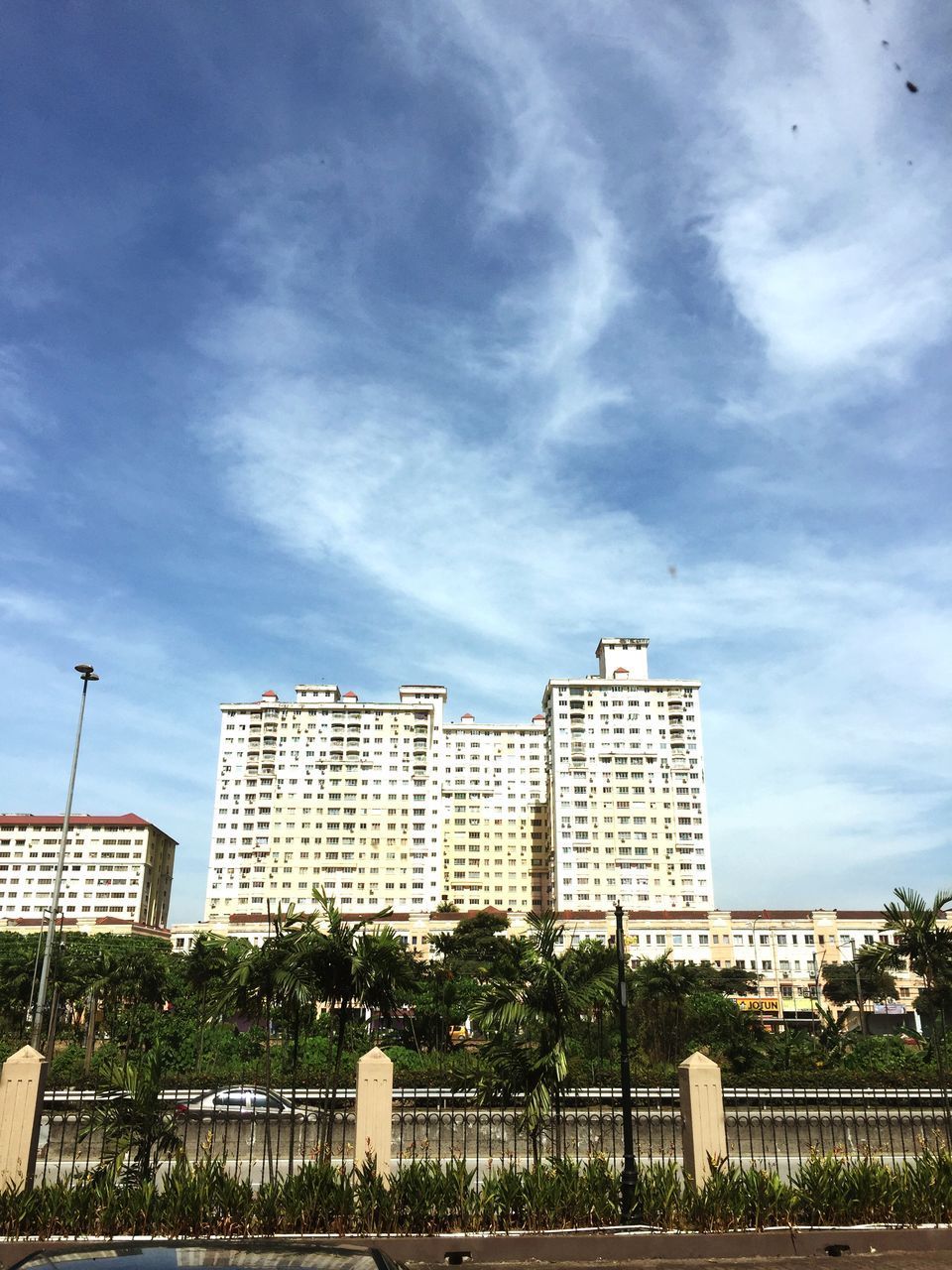 LOW ANGLE VIEW OF BUILDING AGAINST CLOUDY SKY