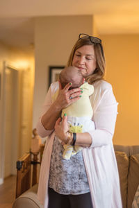 Happy mother holding baby at home