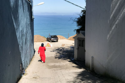Rear view of woman walking on sea shore