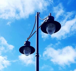 Low angle view of street light against blue sky