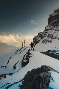 Scenic view of snow covered land against sky during sunset