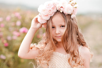 Portrait of cute girl wearing wreath at farm