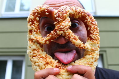 Close-up of man holding pretzel