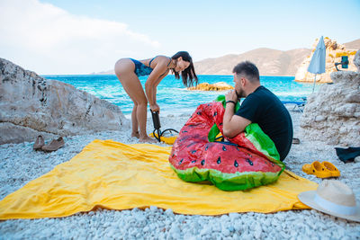 Rear view of woman sitting at beach