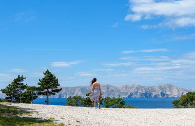 Woman from behind. walking, wind, sea, background, nature, summer.