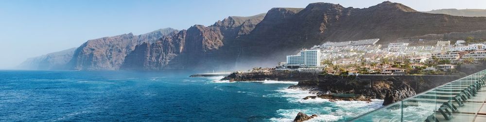 Panoramic view of sea and mountains against sky
