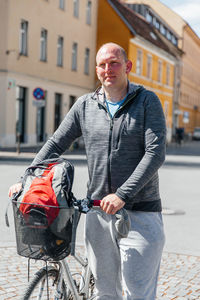 Portrait of a handsome hipster man. a man in a big city cycling down the street on a bicycle