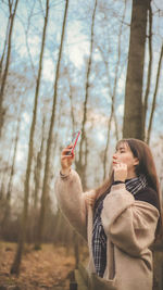 Young woman using smart phone in forest