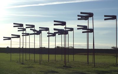 Information sign on field against sky