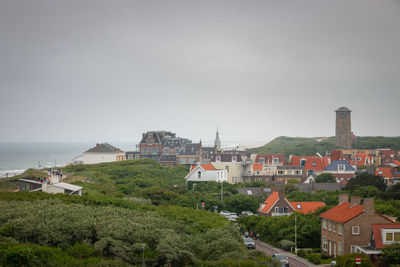 High angle view of townscape by sea against clear sky