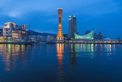 Illuminated modern buildings in city against sky