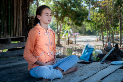 Girl meditating with eyes closed mind training in a quiet old wooden house