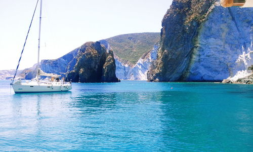 Boats in sea with mountains in background