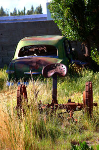 View of abandoned car on field