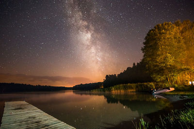 Scenic view of lake against sky at night