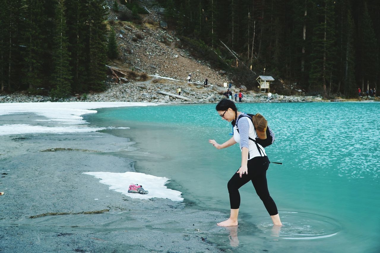 WOMAN STANDING IN WATER AT PARK