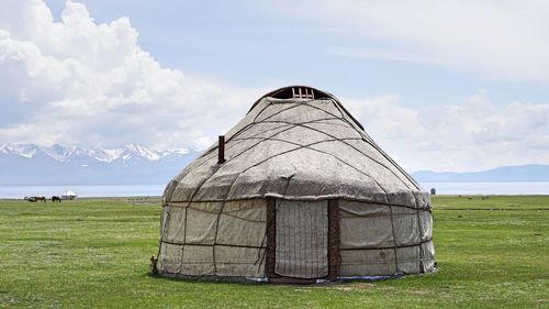 Built structure on field against sky
