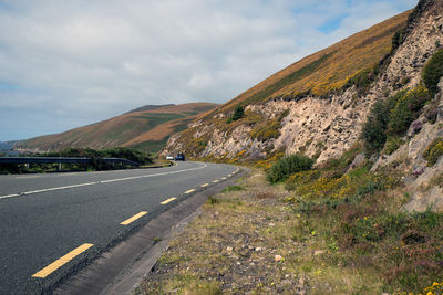 Road by mountain against sky