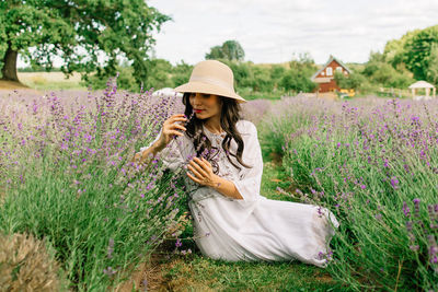 Woman holding umbrella while standing on field