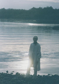 Rear view of man looking at sea against sky