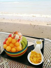 Close-up of fruits in bowl on table at beach