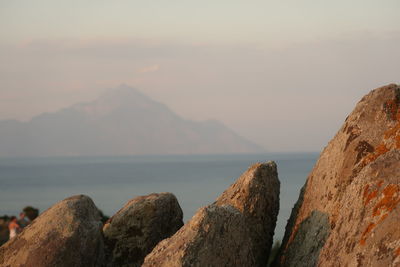 Panoramic view of rocks and sea against sky during sunset