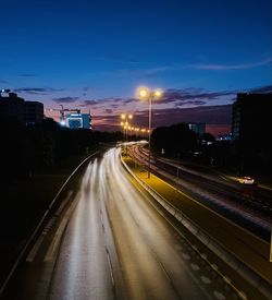 Light trails on road against sky at night