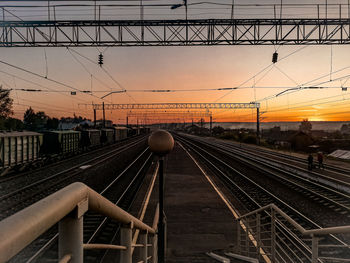 Train at railroad station against sky during sunset